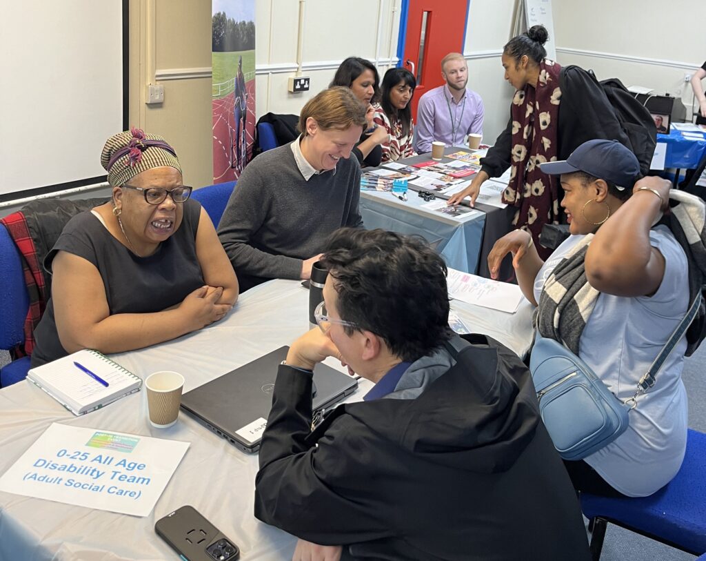 Service providers sharing information with service users; a series of people seated at a table.