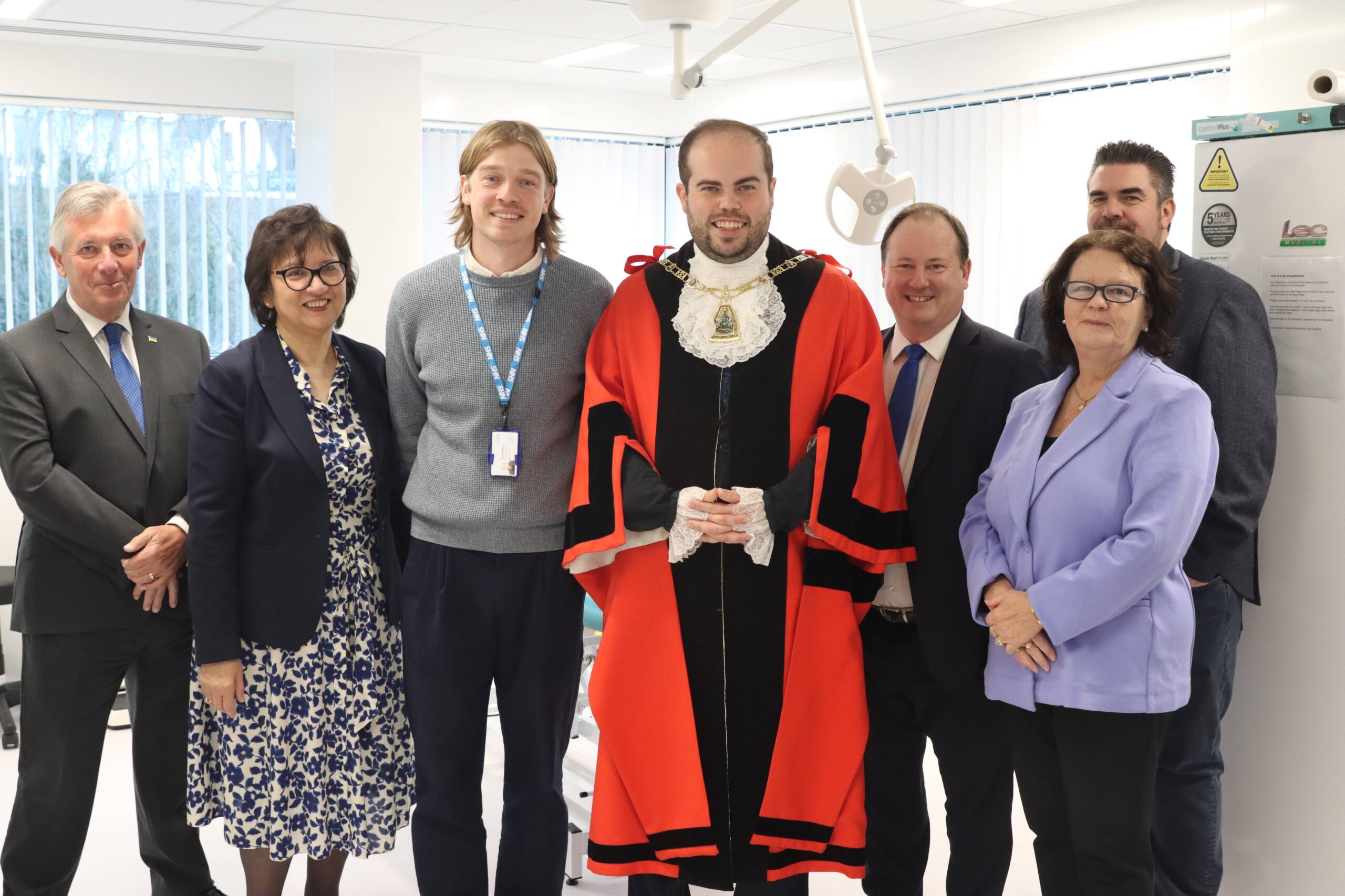 Members of SEL ICB, Bromley Council and the Mayor of Bromley standing smiling in the Bromley Health and Wellbeing Centre.