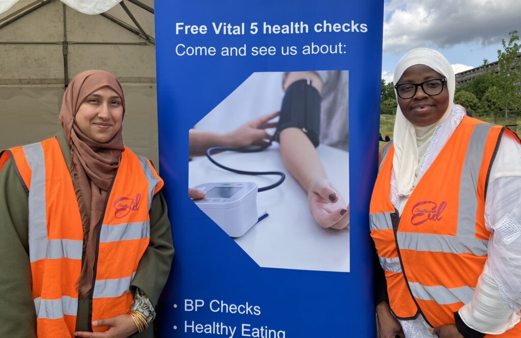 Southwark Health Champions Razna and Saidat beside the vital 5 standing sign