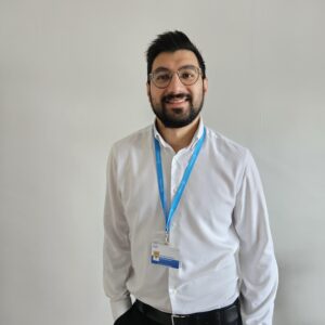 Image of Shabaz smiling at the camera with his NHS lanyard on.