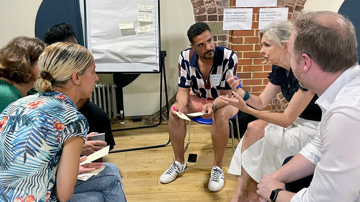 Participants in a break-out discussion group including Chris French from Lambeth Links (centre of photo), Sarah McClinton (speaking) Place Executive Lead for Greenwich, Mike Fox, SEL ICB Chief Finance Officer and Tal Rosenzweig, SEL ICS Director of Voluntary Sector Collaboration and Partnerships