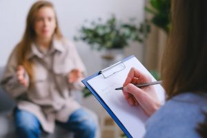 A woman talks to another one who is writing something on a notepad